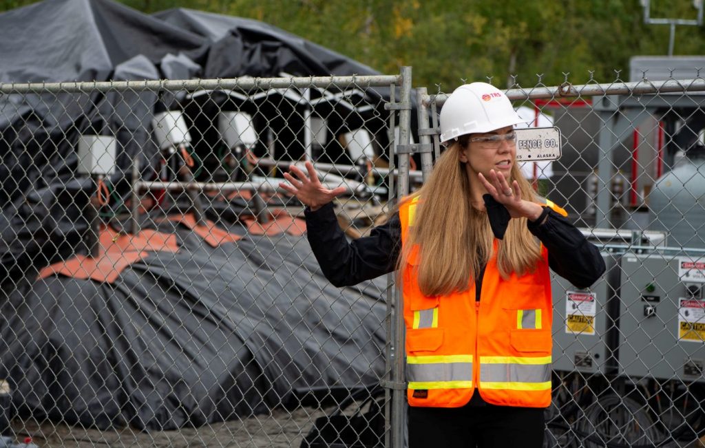 Emily Crownover, ingénieure principale en chef, dirige une visite à la base aérienne d'Eielson à Fairbanks, en Alaska, où TRS a utilisé du TCH sur des stocks de sol ex situ contenant des PFAS (photographiés en arrière-plan).