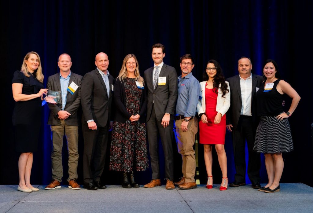 Lauren Soos da TRS (quarta da esquerda), Gerente Sênior de Vendas e Marketing, e Chris Thomas (sexto da esquerda), Diretor de Operações, aceitam a Seção de Illinois do Outstanding Engineering Achievement Award da American Society of Civil Engineers por um projeto abaixo de US$ 10 milhões.