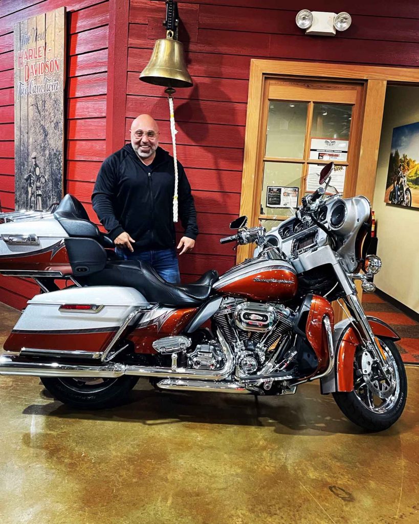 Motard passionné, Gabe pose avec une Harley.