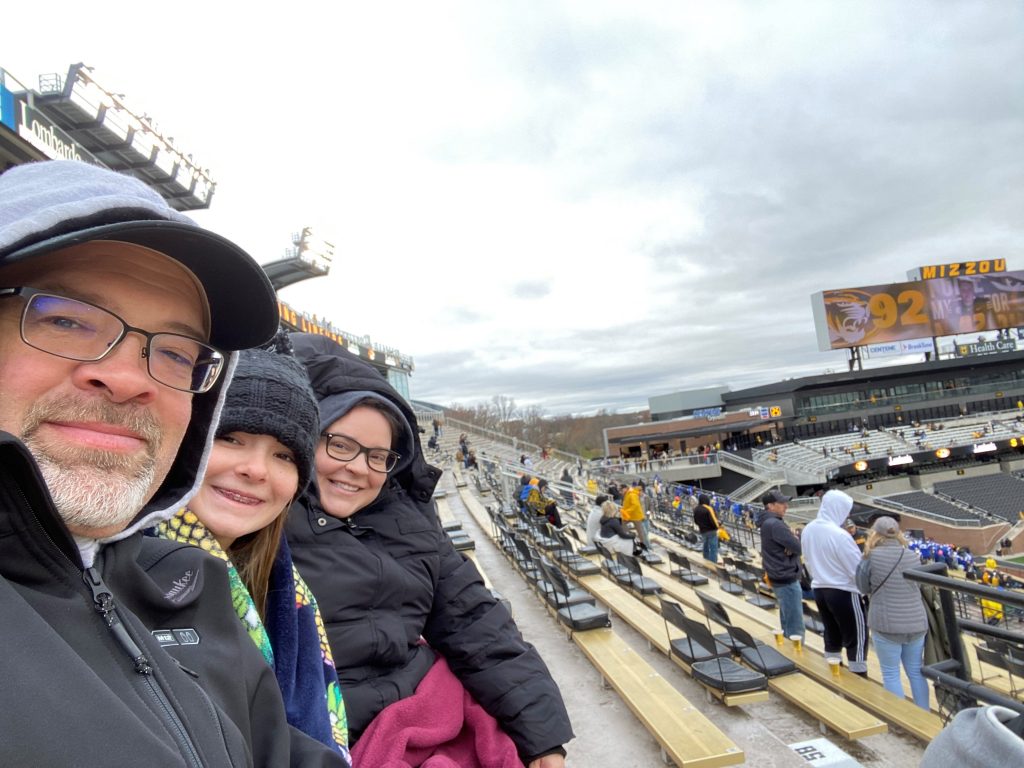 Michell e sua família assistem a um jogo de futebol americano da Universidade do Missouri.