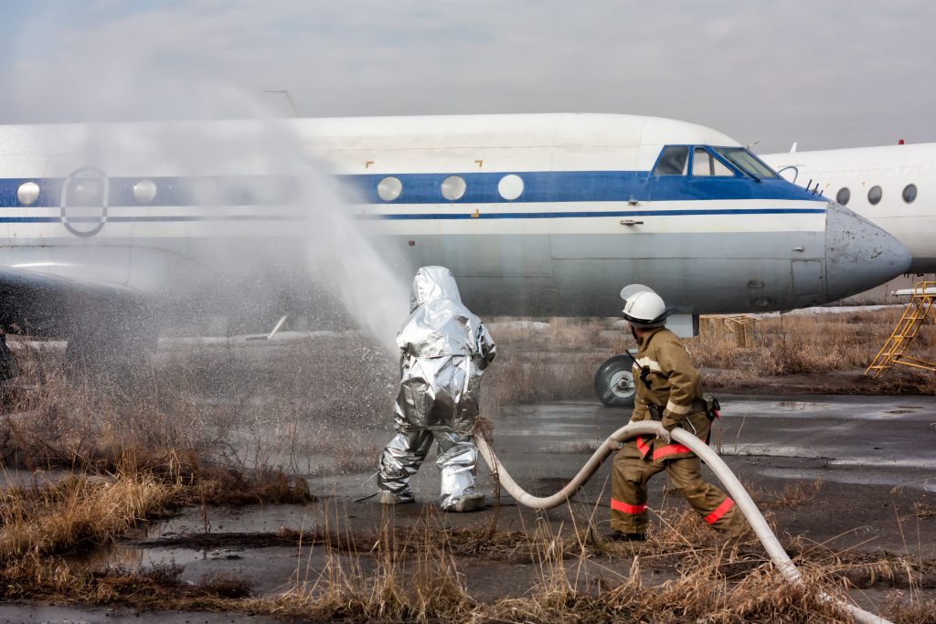 消防员向飞机喷洒水成膜。