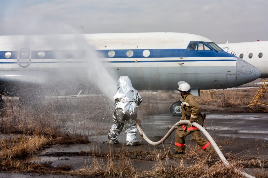 Brandweerlieden spuiten een vliegtuig met AFFF.