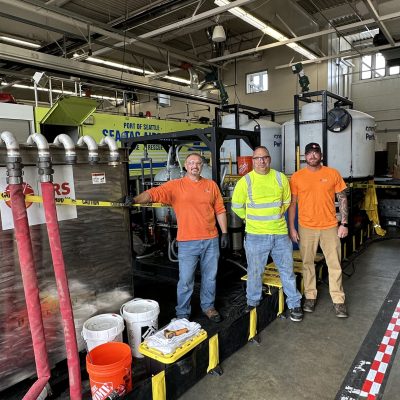 Steve Pistoll (far left) poses for a picture during an AFFF clean out of fire vehicles for transition to F3 at Seattle-Tacoma International Airport.