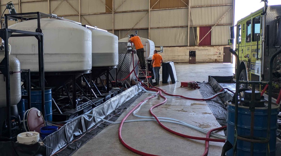 Two TRS system specialists work on the PerfluorAd system at Los Angeles International Airport.