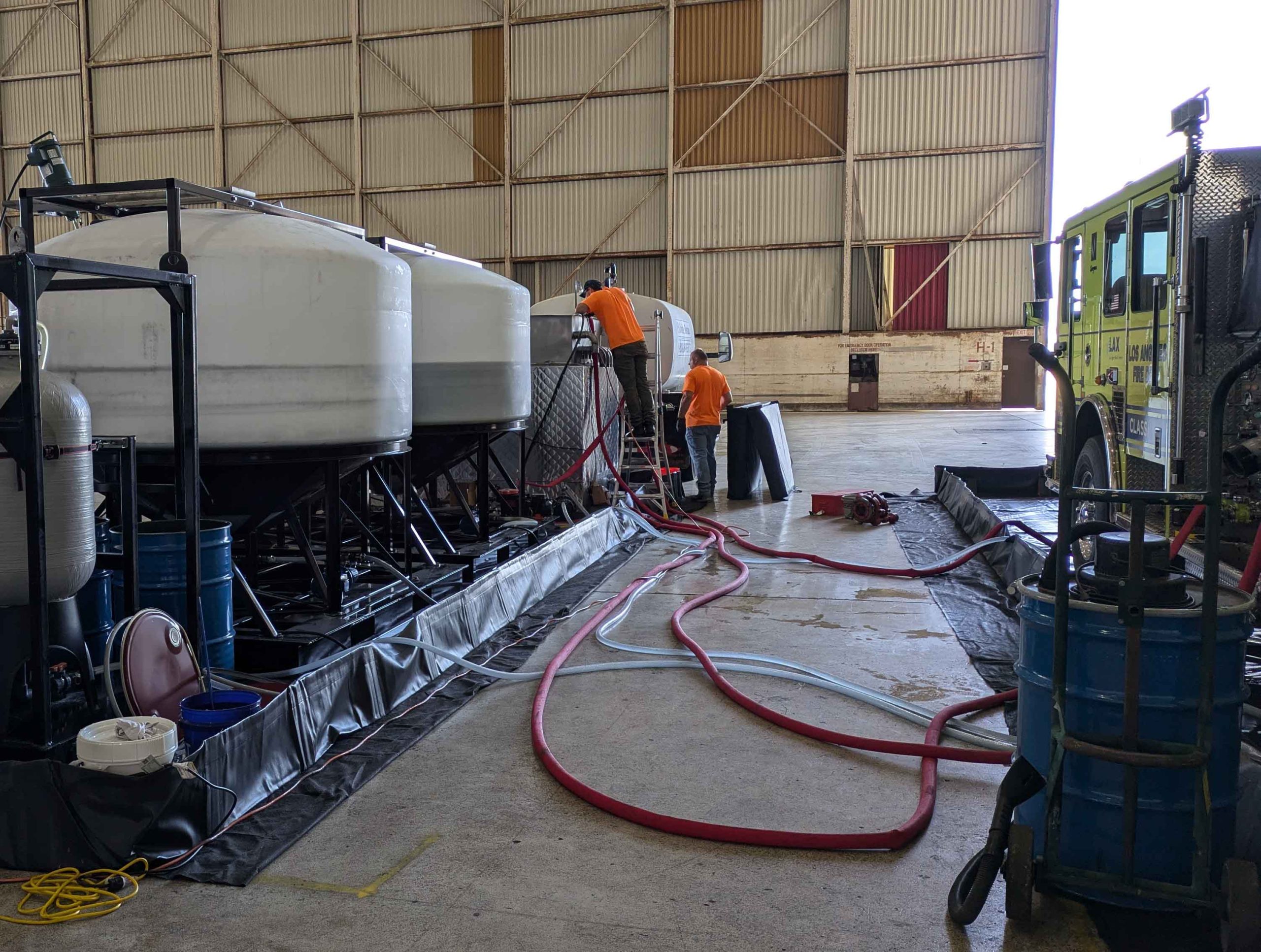 Two TRS system specialists work on the PerfluorAd system at Los Angeles International Airport.